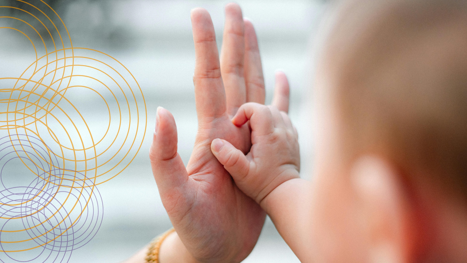 An adult hand touching a baby's hand- a foundation of communication